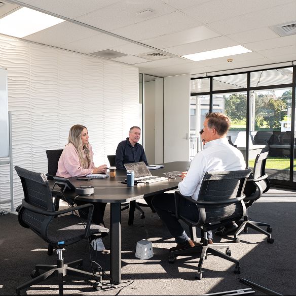 Staff discussing industrial storage projects at meeting table